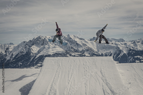 snowboarders jumping synchronous
