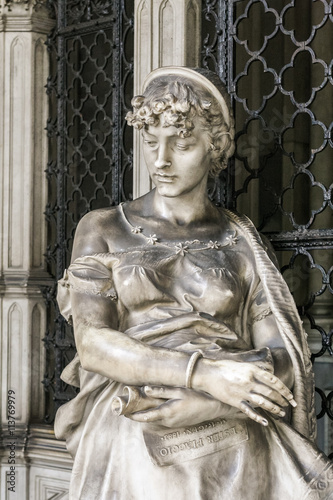 Statue of a grieving girl on monumental cemetery of Staglieno in Genoa.