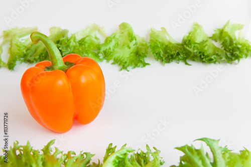 Fresh ripe vegetables - sweet  orange pepper and leaves of frillis. Bell peppers. photo