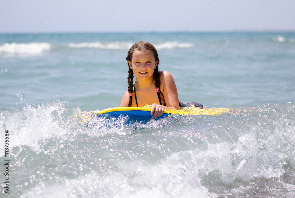 young girl with surfboard at sea