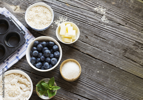 Healthy homemade cakes. Ingredients for blueberry muffins on a dark wooden background