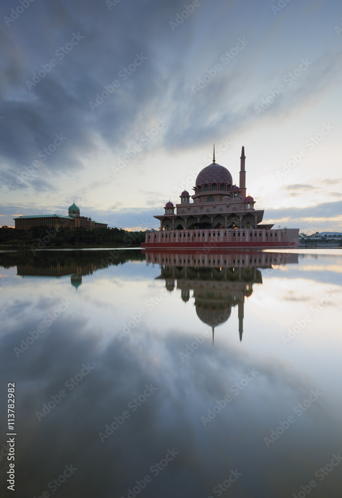 A portrait shot of a mosque with beautiful reflection of clouds.