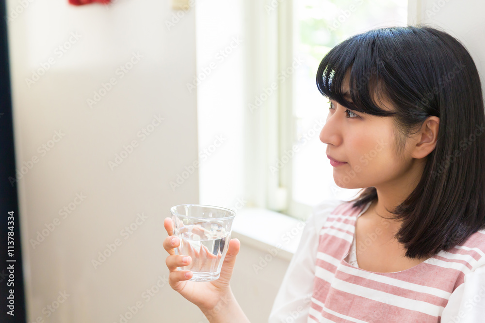 部屋で水を飲む女性 部屋で水を飲む女性