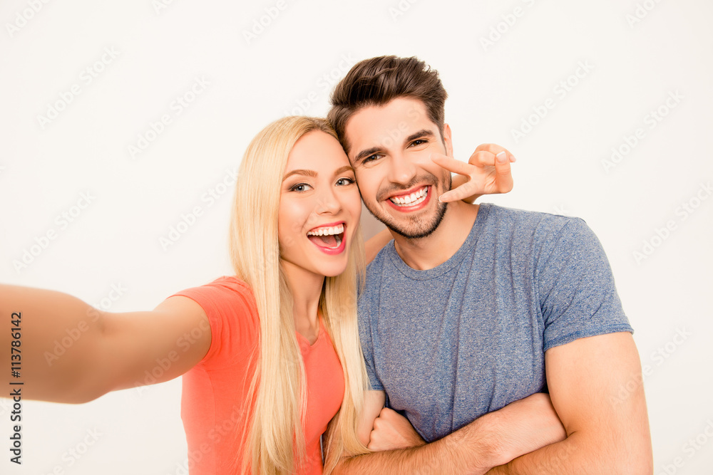 Happy man and woman having fun and showing two fingers while sho Happy man and woman having fun and showing two fingers while sho