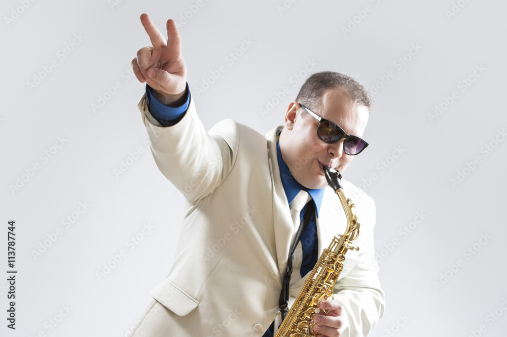 Fototapeta premium Music Concepts and Ideas. Portrait of Hadnsome Male Saxophone Playing and Showing V sign