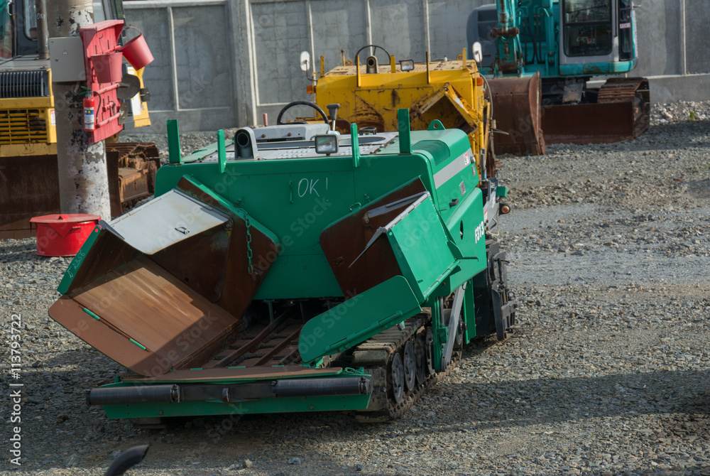 Old small asphalt paver  in the parking lot