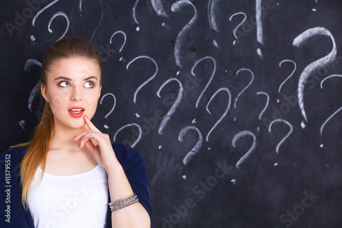 Young girl with question mark on a gray background