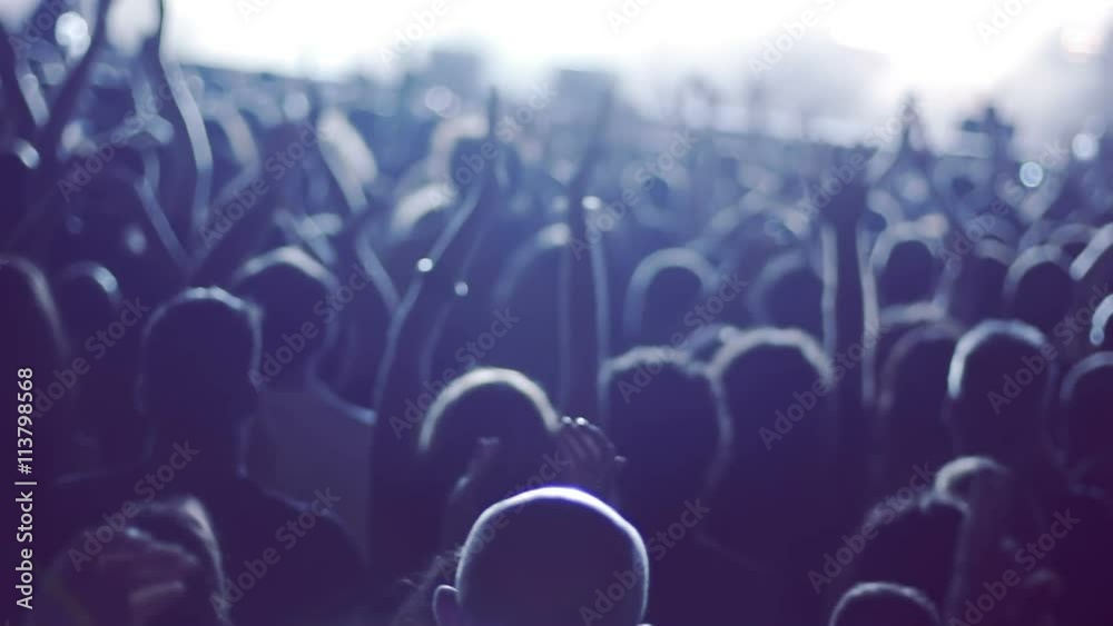 Iconic rock concert front row crowd cheering hands in air slomo crane pan 100p.Night rock concert.People cheer move lift and clap their hands in unison against the strobing stage lights.