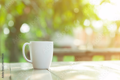 white ceramic coffee cup with blur garden background