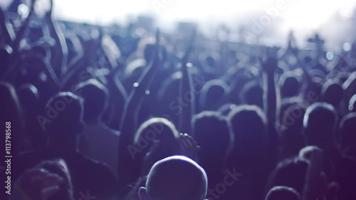 Iconic rock concert front row crowd cheering hands in air slomo crane pan 100p.Night rock concert.People cheer move lift and clap their hands in unison against the strobing stage lights.