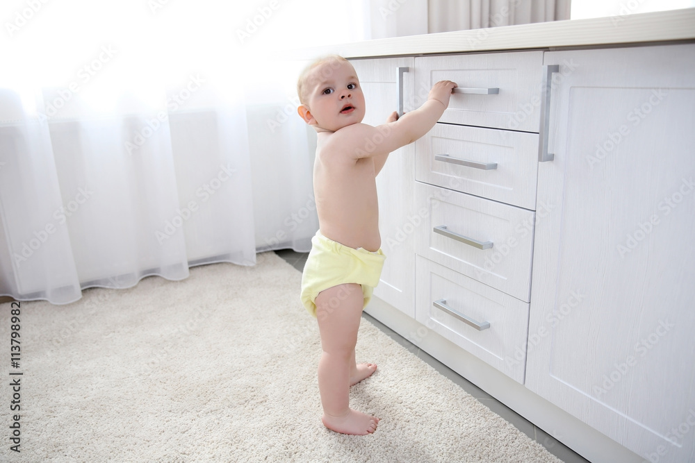 Baby boy playing with drawers in the room Baby boy playing with drawers in the room