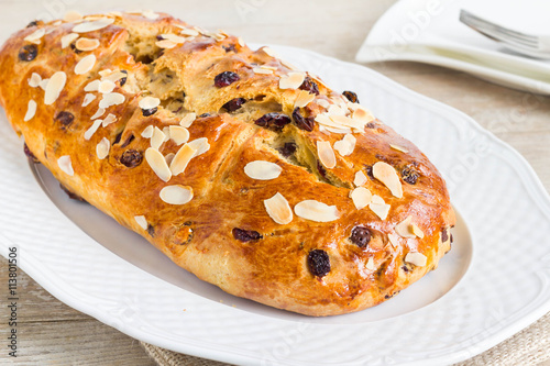 Whole fruitbread on white plate. Full with chocolate and dried fruits. photo