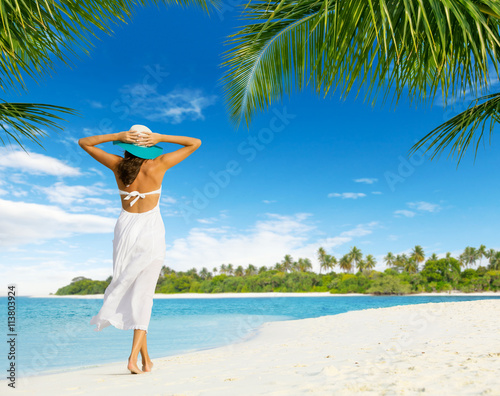 Fototapeta Naklejka Na Ścianę i Meble -  Beautiful girl walking on tropical beach