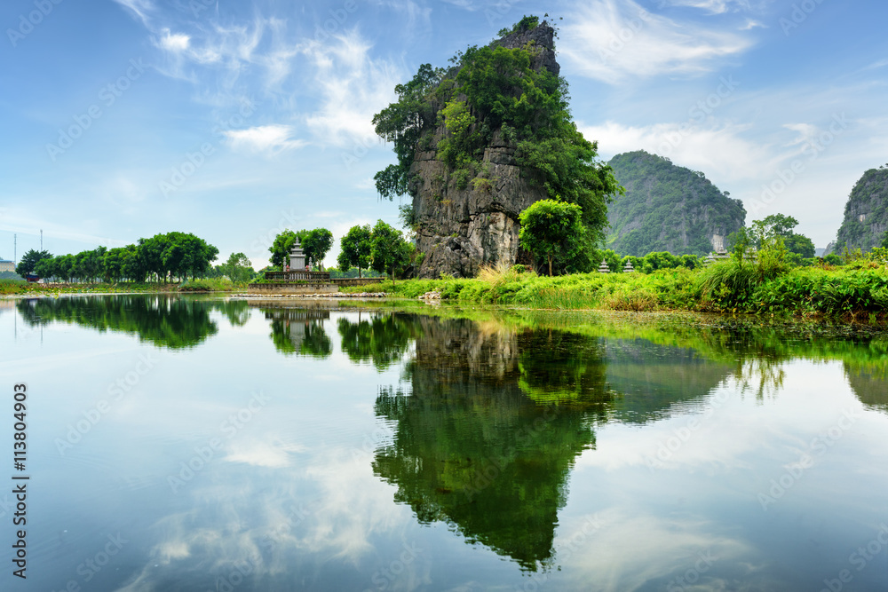 Scenic natural karst tower reflected in water, Vietnam