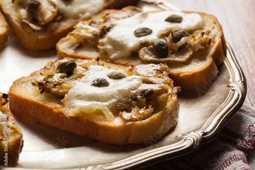 Crostini with fried mushrooms, onion and mozzarella cheese