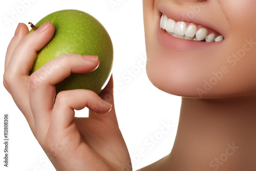 Closeup of the face of a woman eating a green apple  isolated