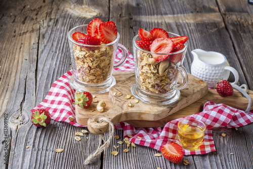 Healthy breakfast dessert. Home crunchy granola with nuts and fresh strawberries