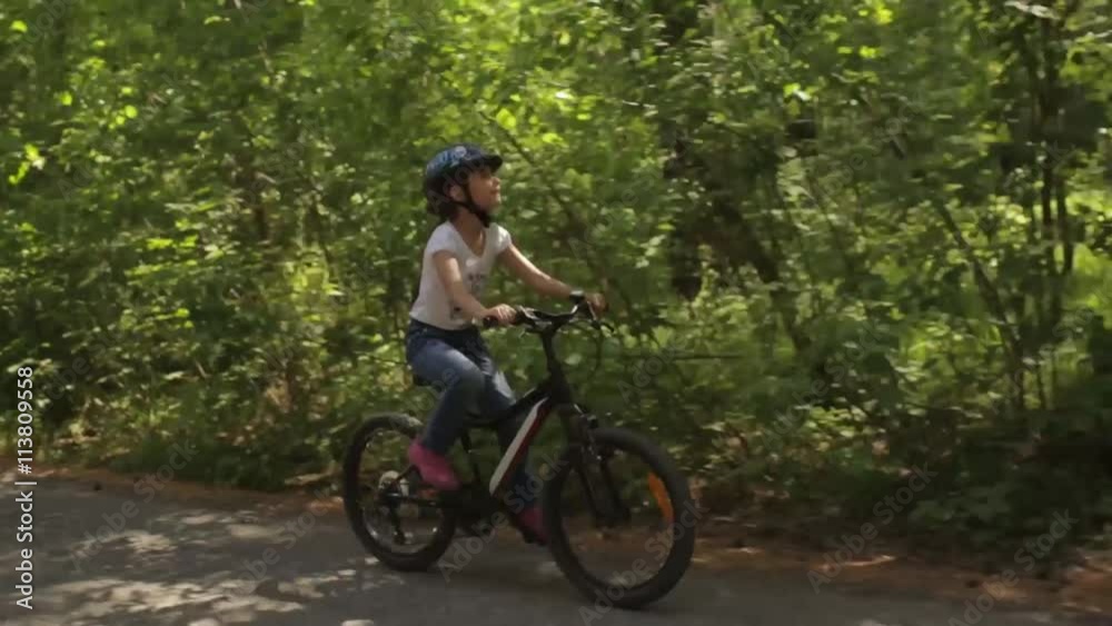 little girl rides her bike on a forest trail little girl rides her bike on a forest trail