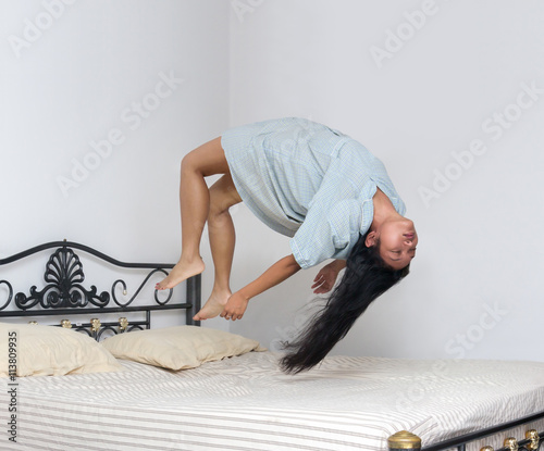 Fotografía levitating girl sleeping over the bed