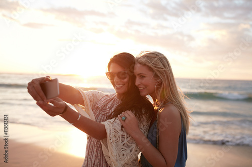 Canvas Print Happy young women taking selfie on the beach