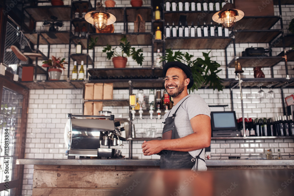 Happy young bar owner standing at the counter Happy young bar owner standing at the counter