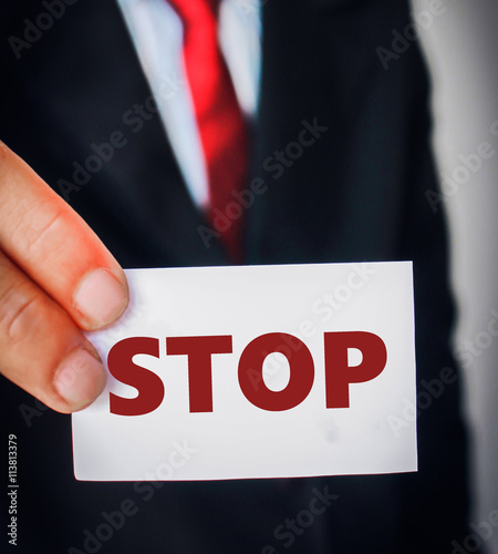 Businessman showing paper writing "STOP" sign.