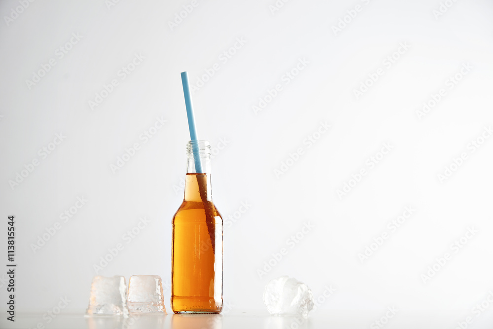 Tasty fresh cocktail in transparent bottle with blue drinking straw near ice cubes isolated on white Tasty fresh cocktail in transparent bottle with blue drinking straw near ice cubes isolated on white