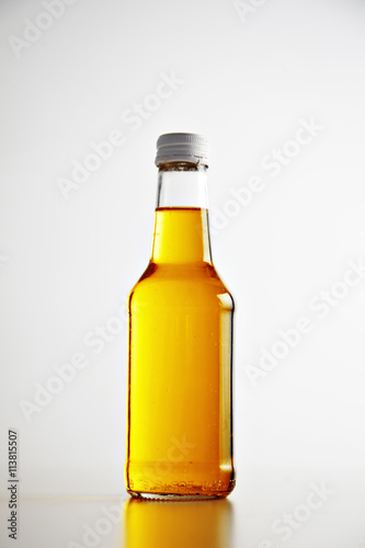 Craft unlabeled bottle closed and sealed with metal cap  with beer cocktail inside presented on white isolated