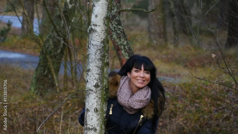 pretty smiling woman in autumn forest posing for photographer