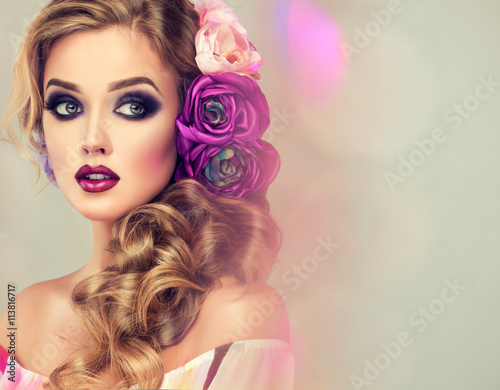 Summer  woman . Beautiful model with flower wreath on his head . Makeup smoky eyes . Summer girl with trendy makeup . 