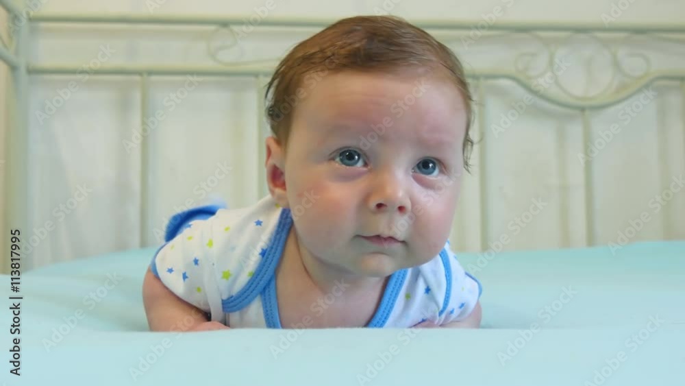 Portrait of a three months old baby boy on the bed in nursery room Portrait of a three months old baby boy on the bed in nursery room