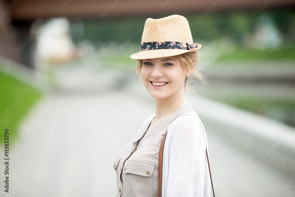 Headshot portrait of happy beautiful caucasian woman wearing casual clothing. Young female standing on the street in summer and looking at camera. Attractive model posing with cheerful expression
