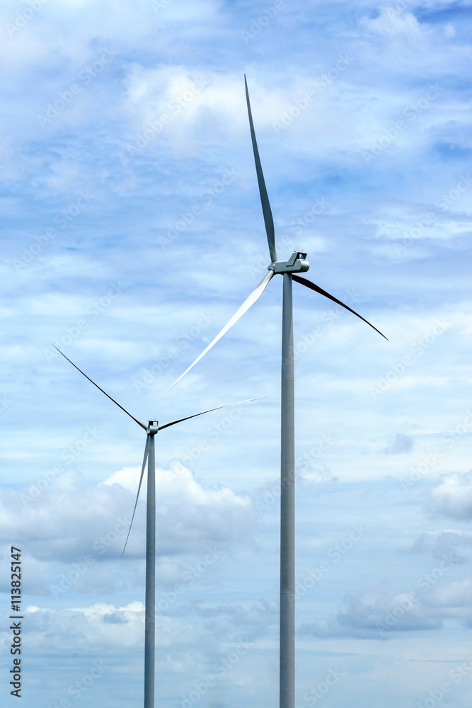 wind turbine against partly cloudy blue sky wind turbine against partly cloudy blue sky