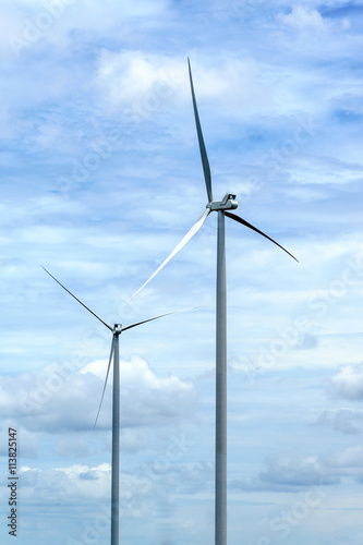 wind turbine against partly cloudy blue sky