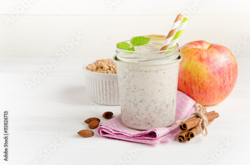 Milk smoothies on pink napkin and apple