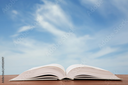 Open book over the landscape background