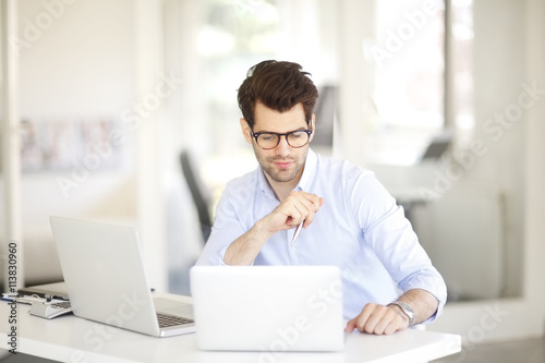 Businessman thinking about the best solution while working on laptop at office