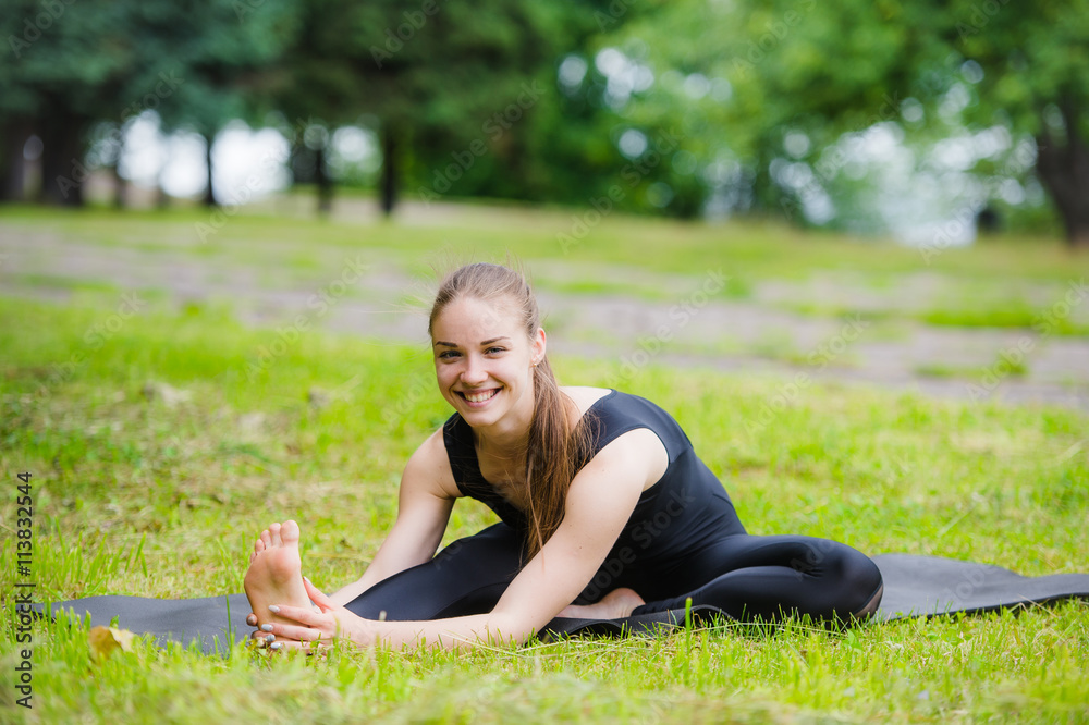 Woman stretching outdoors in a park before yoga practice Woman stretching outdoors in a park before yoga practice