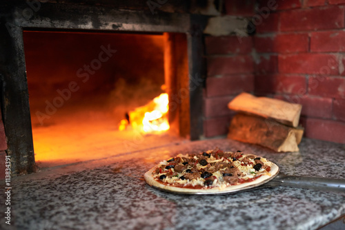 raw pizza lay down stove with the fire on blade.