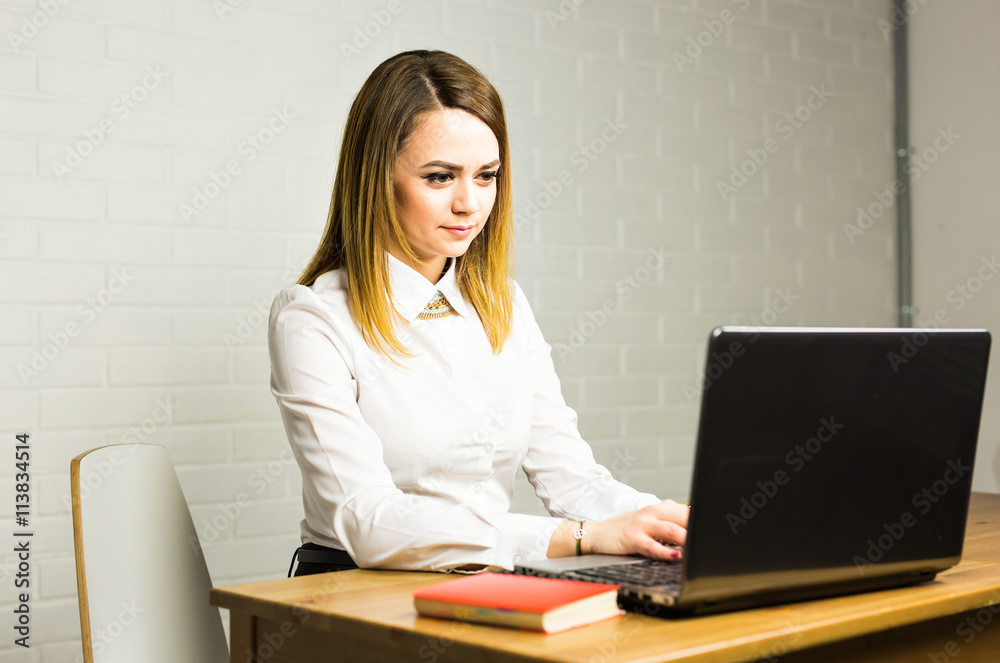 Portrait of beautiful young woman working with laptop in her office. Portrait of beautiful young woman working with laptop in her office.