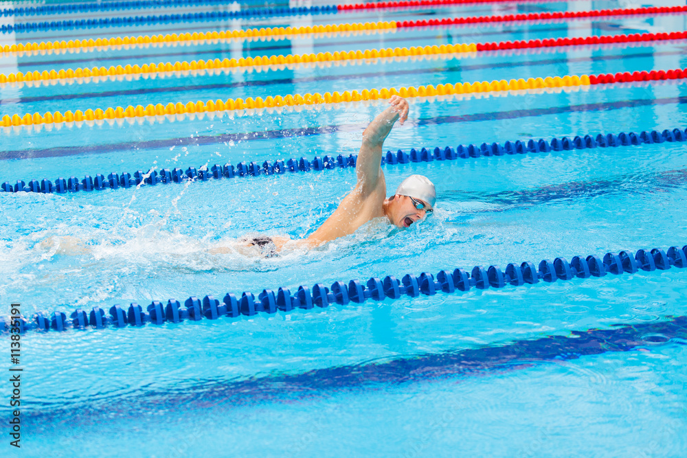 Man swimmer swimming crawl in blue water.