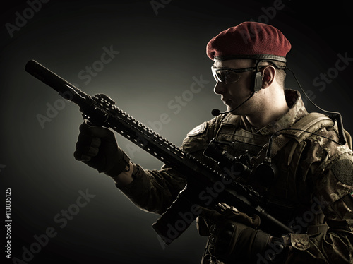 Young military man in italian camouflage holding automatic rifle photo