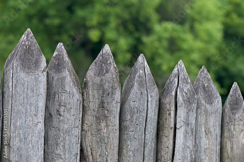 Fence stakes, a fence made of logs, tapered wooden stakes.