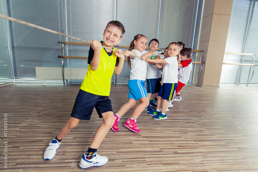 Group of kids pulling a rope in fitness room Group of kids pulling a rope in fitness room
