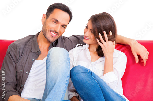 Smiling young man with girlfriend on sofa © Ambrophoto
