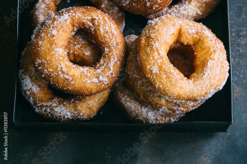 Homemade donuts with sugar and sugar powder in old metal background. 