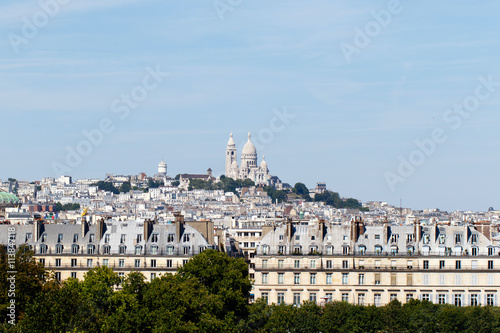 Basilica of the Sacre Coeur on Montmartre, Paris, France with the capital cityscape in the foreground. Horizontal with copy space for text