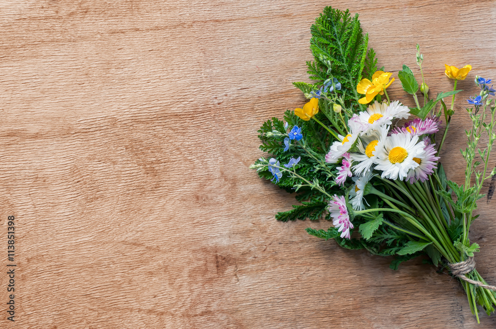 Φωτογραφία Wildflowers bouquet on wooden grunge backdrop. Top view