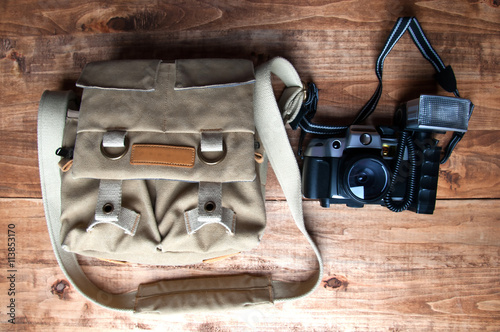 Old camera and bag, wooden background