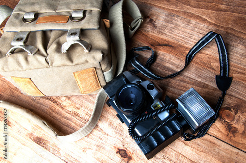 Old camera and bag, wooden background